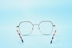 pair of red plastic-rimmed eyeglasses on a blue background photo