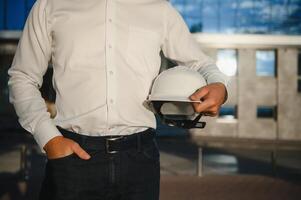 Hand's engineer worker holding safety helmet with building on site background. photo