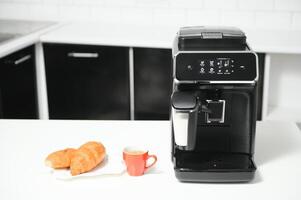 Modern coffee machine on table in kitchen photo