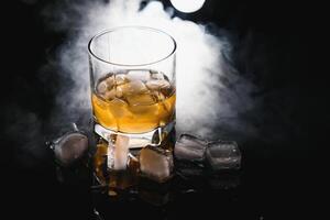 Glass of scotch whiskey and ice photo