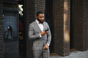 Portrait of an African American businessman wearing a suit standing in an outdoor business environment photo