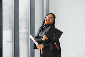 Alegre estudiante de posgrado afroamericano con diploma en la mano foto