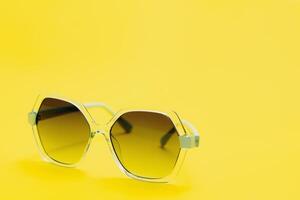 yellow sunglasses on yellow background photo