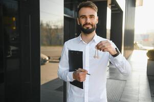 Businessman or real estate agent ready to discuss business and stands against new building photo