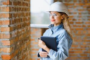 Warehouse woman worker. Woman builder in hardhat. Girl engineer or architect. Home renovation. Quality inspector. Construction job occupation. Construction worker. Lady at construction site photo