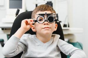 alegre niño chico en lentes cheques ojo visión pediátrico oftalmólogo foto