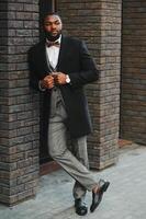 Fashion portrait of a handsome young African American business man walking outdoors in a casual pose. photo