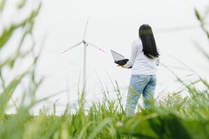 Environmental engineer with a laptop at wind farm photo