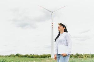 mujeres ingenieras trabajando y sosteniendo el informe en la estación generadora de energía de la granja de turbinas eólicas en la montaña, gente de tailandia foto