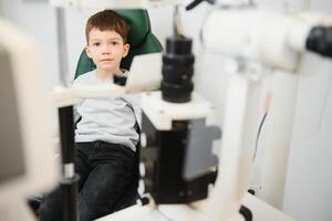 Boy checks eye vision in ophthalmology clinic. photo