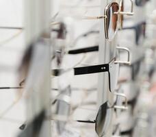 rack with glasses and sunglasses close up. photo