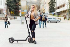 niña en eléctrico scooter montando en el antiguo ciudad centrar foto