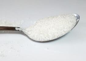 cucharilla azúcar aislado en blanco antecedentes foto