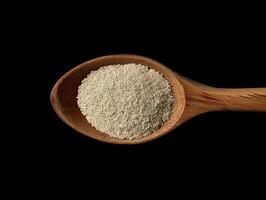 AI generated Active dry yeast granules pile with wooden spoon photo