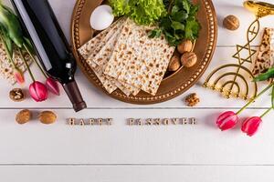 Festive background for the spring holiday of the Jewish Passover. Traditional foods, flowers, minor candlestick. Text of Happy Passover photo