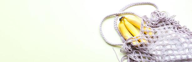 Banner Flat lay ecology. Bananas in an eco bag.  Mesh bag photo