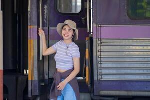 Young woman with suitcase waits at the metro station while the train arrrives, Tourism and travel in the summer. Vacations for the student. Work and travel photo