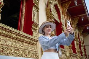 Traveler Asian woman traveling and walking in Bangkok Chiang Mai Temple, Thailand, backpacker female feeling happy spending relax time in holiday trip photo