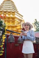 Traveler Asian woman traveling and walking in Bangkok Chiang Mai Temple, Thailand, backpacker female feeling happy spending relax time in holiday trip photo