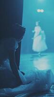 The ballerina prepares and spies on the stage for another ballet dancer. Ballet. Life behind the scenes. Intrigue and rivalry. Secrets of ballet. Theater from the inside. Vertical format for phone. video