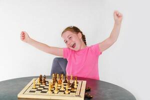 niña alegría desde victorioso ajedrez foto