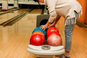 mayor mujer elegir un pelota en un bolos club foto