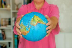 woman holding out physical globe photo