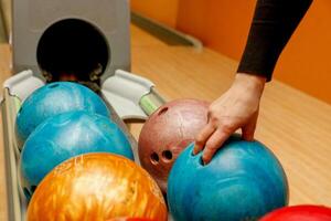 mujer mano selecciona un bolos pelota foto