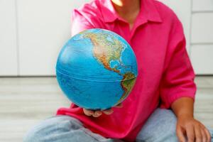 woman holding out physical globe photo
