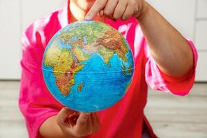 woman holding a physical globe in her hands photo