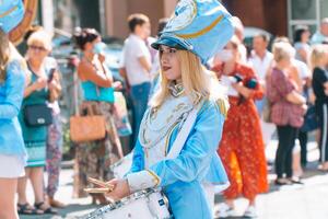 Ternopil, Ukraine July 31, 2020. Street performance of festive march of drummers girls in blue costumes on city street photo