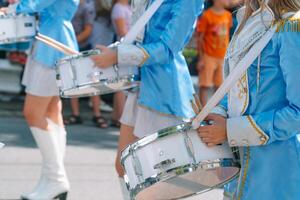 de cerca de hembra manos bateristas son golpes en el tambor de su palos majorettes en el desfile foto