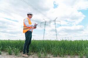 Engineer working near transmission lines. Electrical engineer checks high voltage lines. Transmission towers. Energy efficiency conception photo