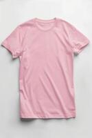 ai generado rosado color camiseta acostado en un blanco antecedentes foto