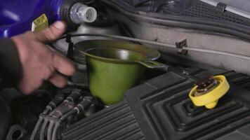 technician adding motor oil in vehicle engine during oil change procedure video