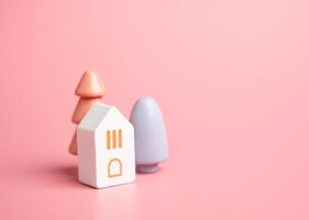 House and colorful trees, figures. Buy a house. Good housing. Mortgage. Cozy and gentle tones. Pastel pink colors. photo