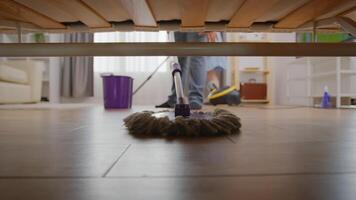 femme nettoyage le sol en dessous de canapé video