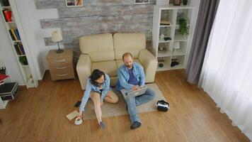 Haut vue de Jeune couple Faire en ligne achats sur portable séance sur tapis dans vivant chambre. video