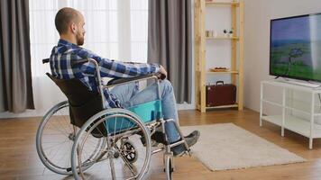 paralizzato e depresso giovane uomo nel sedia a rotelle Guardando tv. video