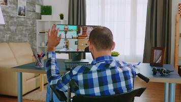 Disabled man in wheelchair during a video call with colleagues.