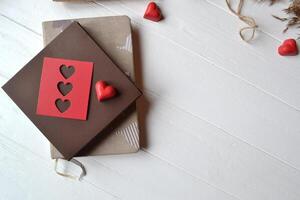 computadora portátil, rojo corazones, cuerda y regalo caja en el blanco de madera escritorio. San Valentín día. antecedentes con sitio para texto. foto