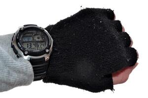 Man looking at watch. Male hand clothes by sport knitted gloves with electronic watch. photo