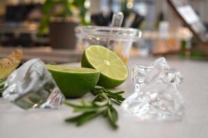 Lime and ice cubes on a white table. Ingredients for healthy lemnade. photo