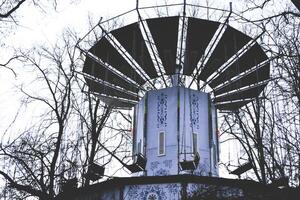 antiguo carrusel en el parque. Clásico columpio a invierno clima. foto