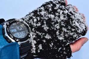 Male hand with watch and snow. photo