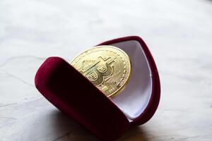 dorado bitcoin en rojo caja. un moneda de criptomoneda foto