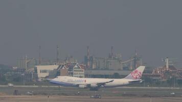 BANGKOK, THAILAND - MARCH 01, 2023 - Wide-body cargo Boeing 747 of China Airlines takes off at Suvarnabhumi Airport, Bangkok. Huge transport carrier departure, side view video