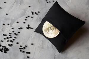 Golden bitcoin in a black box on textured background. Gold coin of cryptocurrency. photo