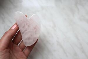 Scraper gua sha, rose quartz. Skin care device. photo