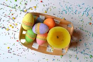 Colorful easter eggs with flowers and yellow candle in the basket. Beautiful easter background. Easter card. Homemade holiday decor. photo